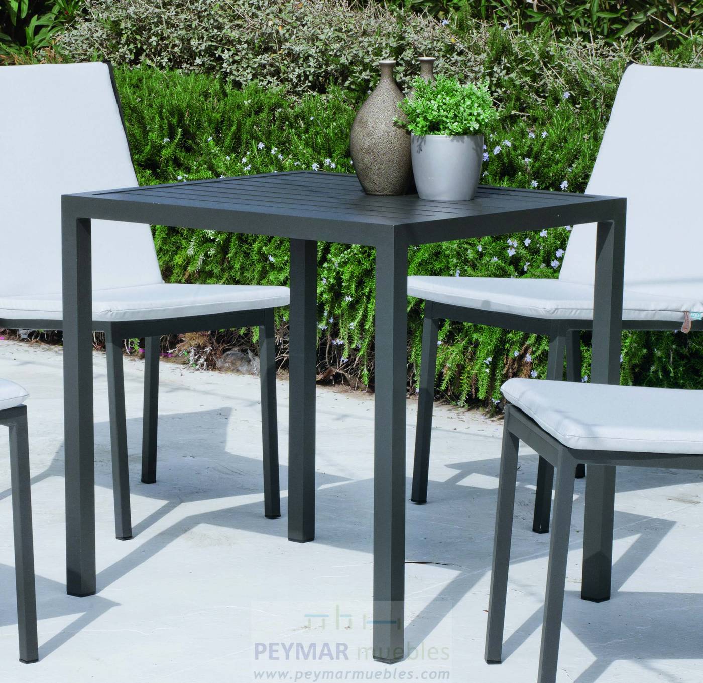 Mesa cuadrada de aluminio, apilable, con tablero de lamas de aluminio. Disponible en color blanco, plata y antracita.